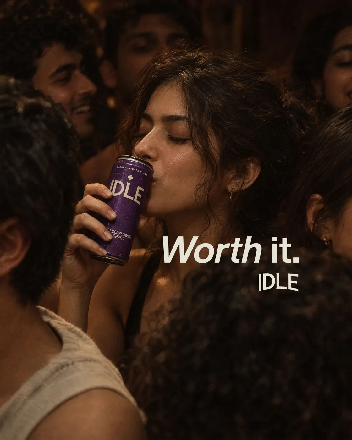 A woman with her eyes closed drinking an IDLE Elderflower Spritz in a crowded room