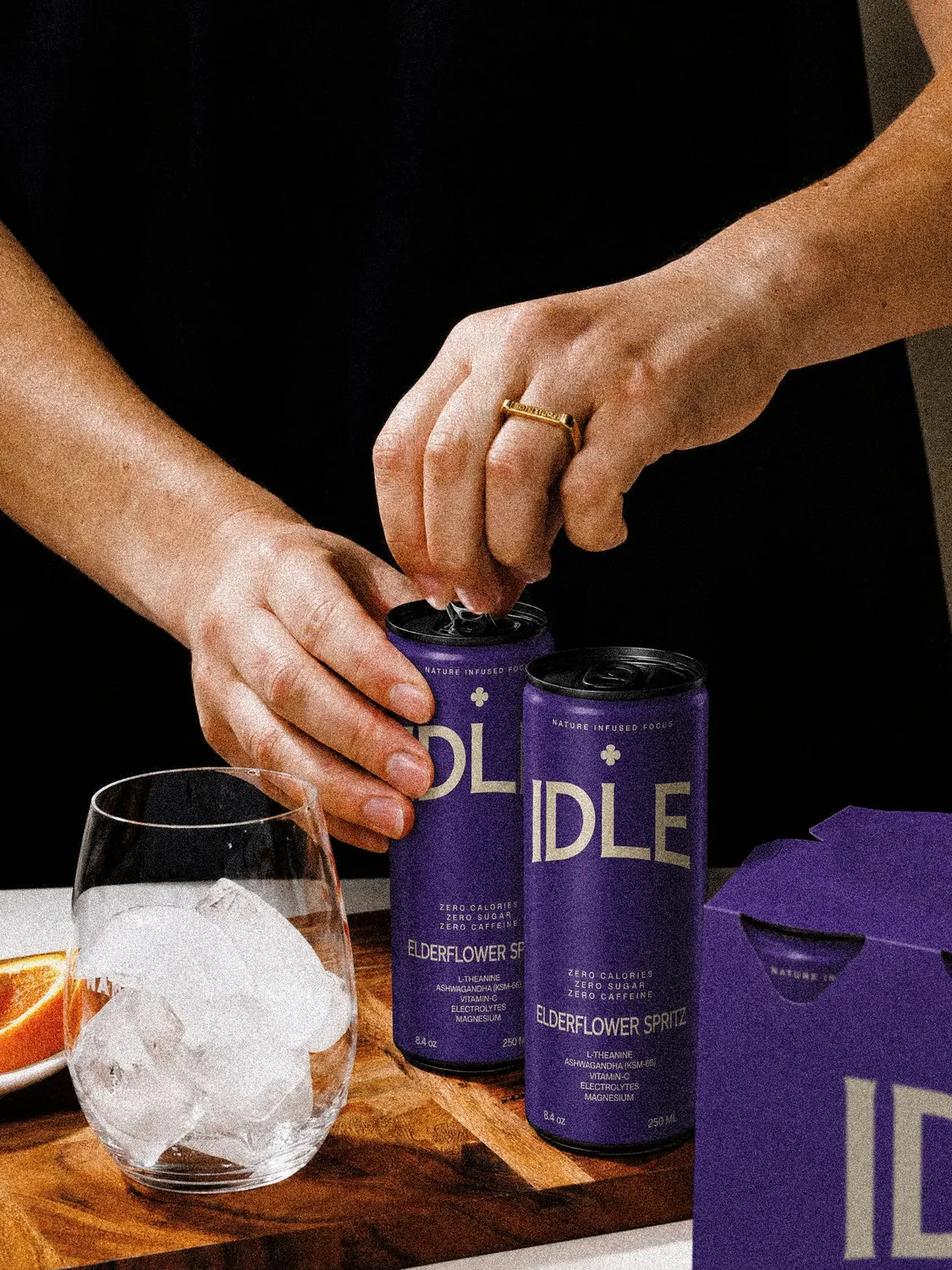 Opening an Elderflower Spritz can beside a glass of ice