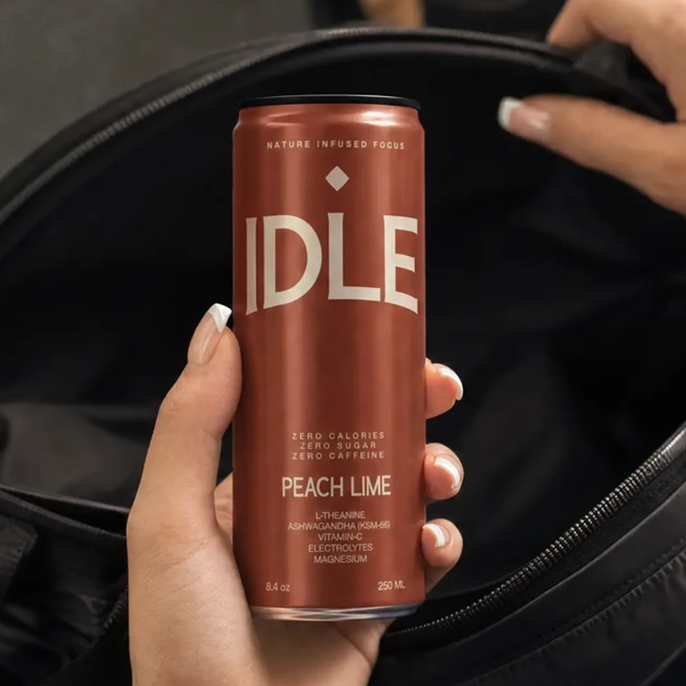 A hand lifting a Peach Lime can out of a black bag